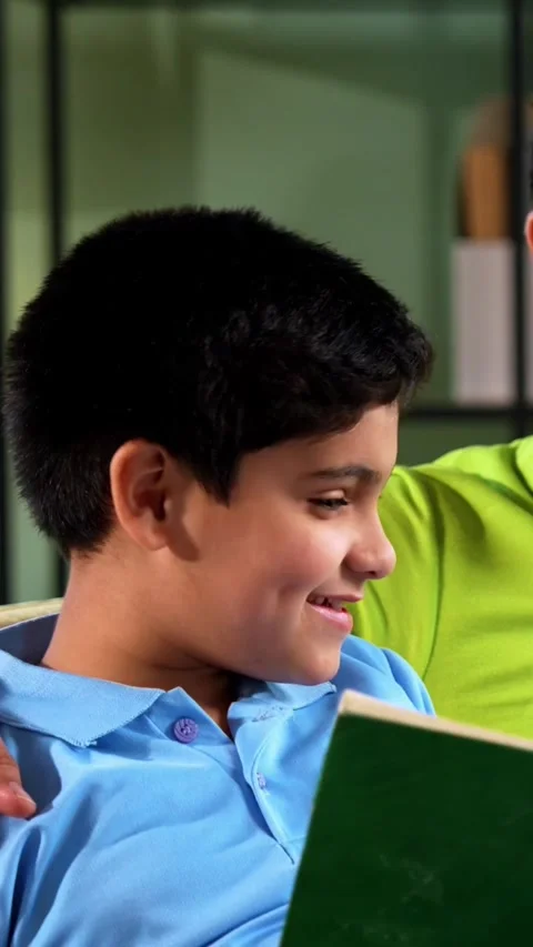 Indian asian son reading book with father as dad supports study time Video stock 342758017