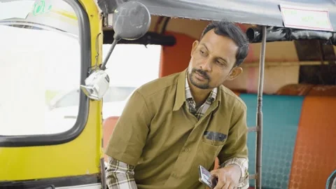 Indian auto rikshaw driver waiting for passenger or customers while sitting on Stock Footage 168694959