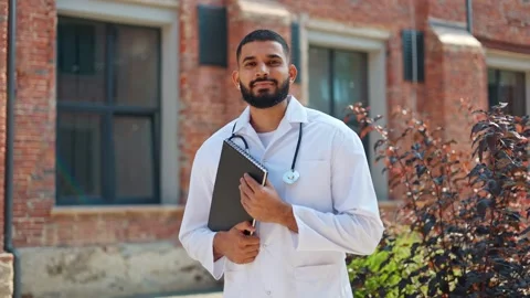 Indian beginner intern posing on camera with black notebook and smiling Stock Footage 250076491