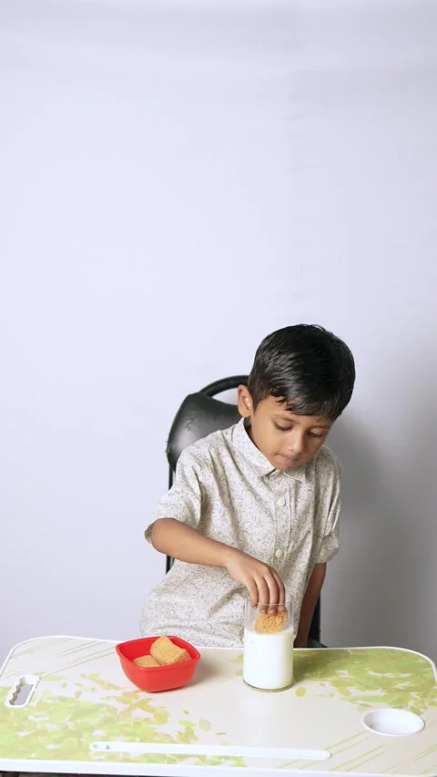 Indian Boy Dipping Biscuit in Milk Stock Footage 341323262