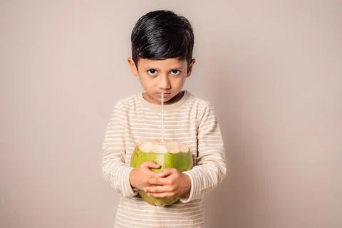 Indian Boy Drinking Fresh Coconut Water at Home Stock Photos