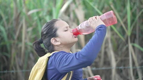 An Indian boy drinking water from bottle while cycling, got tired and thirsty Stock Footage 172181998