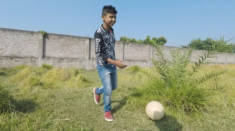 Indian boy kicks ball. Another boy intercepts it, Stock Footage 122899235