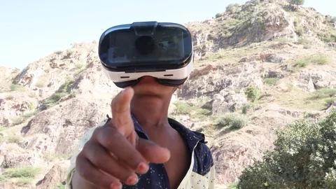 Indian boy wearing and using a VR virtual reality headset  Stock Footage 70412024