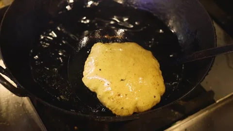 Indian bread or bhatura being fried in oil Stock Footage 297932063
