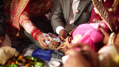 Indian Bride and Groom Performing Wedding Ritual with Metal Vessel Stock Footage 345789409