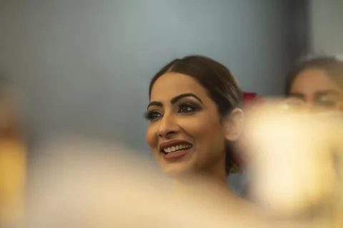 Indian Bride to be getting smiling as she gets her make up done 	 Stock Photos