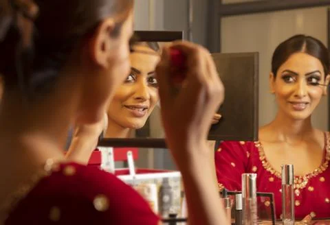 Indian bride doing her make-up	 Stock Photos