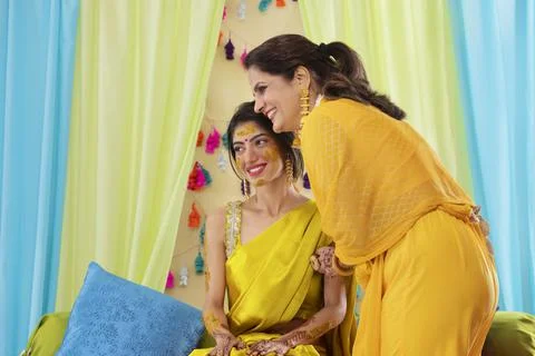 Indian bride looking elsewhere with her mother during haldi ceremony Stock Photos