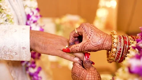 Indian Bride Putting Wedding Ring on Groom's Finger Stock Footage 342097725