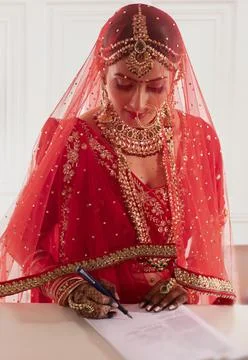 Indian bride signing documents	 Stock Photos