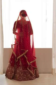 Indian bride standing on the window looking down 	 Stock Photos
