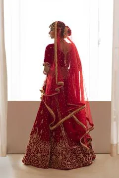 Indian bride standing on the window looking away	 Stock Photos