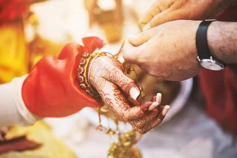 Indian bride ties with holy thread on her wrist focus hand Stock Photos