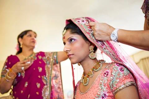 Indian bride wearing colorful fabrics and jewelry Stock Photos