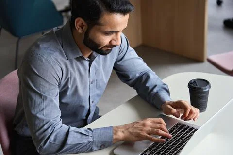 Indian business man working or studying typing on laptop at home office. Stock Photos