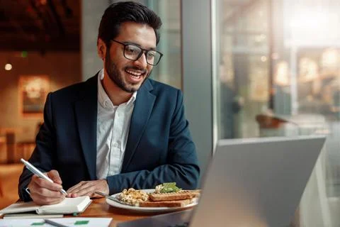 Indian businessman is making notes in notepad during working day in cafe Foto stock