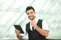 The indian businessman stand by business center work with the tablet Photo