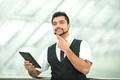 The indian businessman stand by business center work with the tablet Photo