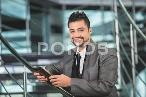 The indian businessman stand by business center stairs with phone Stock Photos