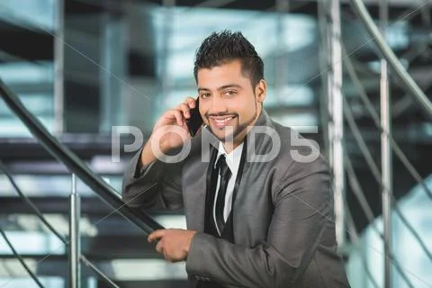 The indian businessman stand by business center stairs with phone Stock Photos