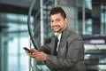 The indian businessman stand by business center stairs with phone Photo