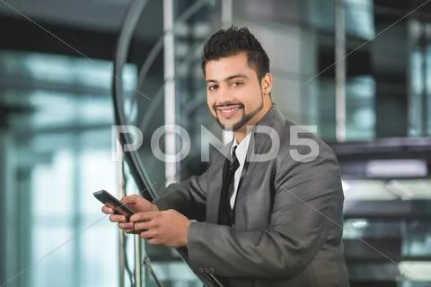 The indian businessman stand by business center stairs with phone Stock Photos
