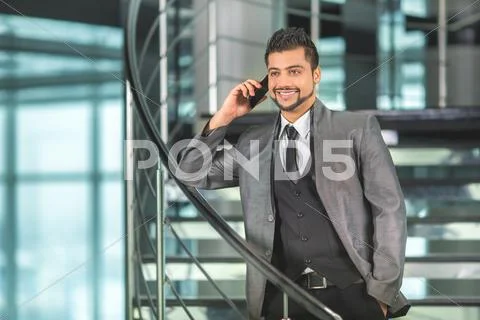 The indian businessman stand by business center stairs, phone and talk Stock Photos