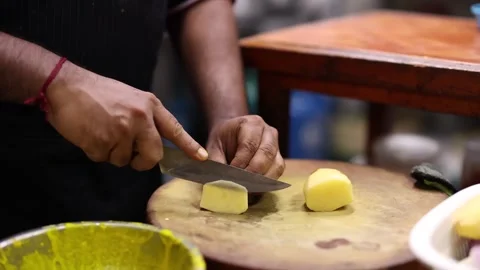 Indian Chef Slicing Raw Potatoes on Round Cutting Board Video stock 346572302