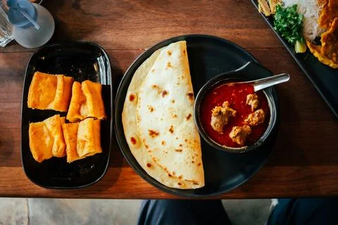 Indian Chicken Curry with Roti Flatbread and Toasted Bread on Wooden Table Stock Photos