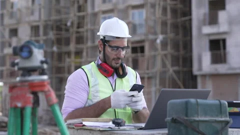 Indian civil engineer using mobile phone to type text message on site. Stockbeeldmateriaal 161811332