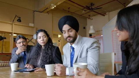 Indian colleagues sitting at a cafe break sipping drinks, tea and coffee, from m Stock Footage 101935918