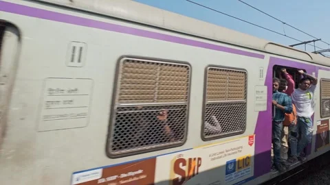 Indian commuter train with passengers passing through a city, close-up. Stock Footage 337241830