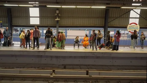 Indian Commuters Waiting For Train To Arrive at Metro Station Platform in Delhi Stock Footage 129865145
