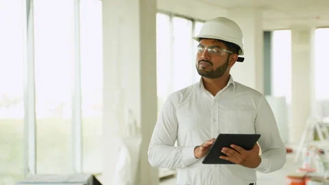 Indian construction engineer reviewing building project with tablet on-site Stock Footage 285671370