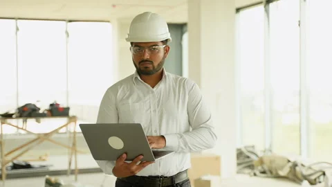 Indian construction engineer using laptop for project analysis on site Stock Footage 285669242