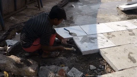 Indian construction worker laying stone slabs on the pavement Stock Footage 83635351