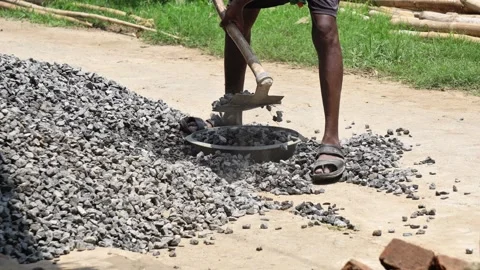 Indian Construction Worker Shoveling Crushed Stone for Road Building Project. Stock Footage 337850543