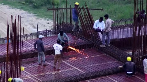 Indian construction workers standing on a rebar covered roof while grinding Video stock 161177438