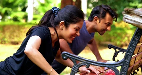 Indian couple doing pushups together on park bench maintaining fitness Stock Footage 342844782