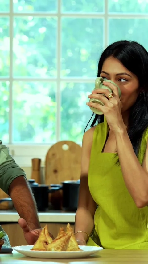 Indian couple drinking coffee together, talking at the kitchen platform Stock-Footage 342689070