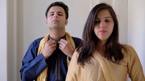 Indian couple getting ready in their finest dresses for an evening look and adju Stock Footage 100631068
