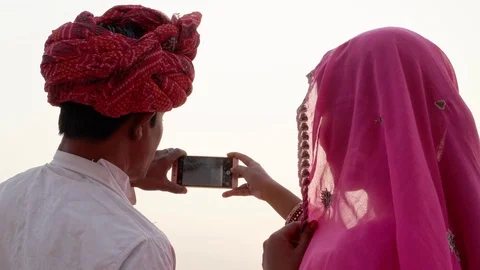 Indian couple looking back at the camera and taking photos of sunset at holy Pus Stock Footage 70204267
