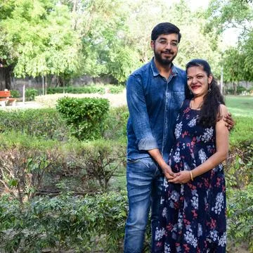 Indian couple posing for maternity baby shoot. The couple is posing in a lawn Stock Photos