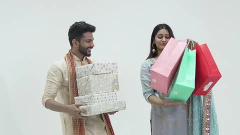 Indian couple presenting gift boxes and shopping bags  with hug Stock-Footage 252586708