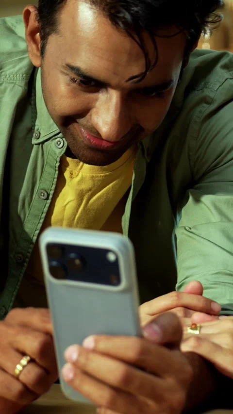 Indian couple surfing internet checking photos on smartphone in kitchen Stock Footage 342689057