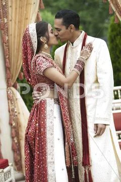 Indian Couple In Traditional Wedding Clothing, Kissing