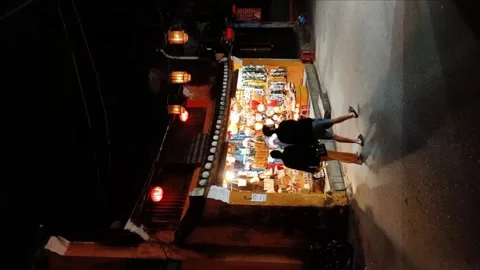 Indian couple walking past a gift shop in Hoi An old town 스톡 동영상 248554337