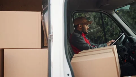 Indian courier checking order list on the tablet while sitting in the van full Stock Footage 150952203