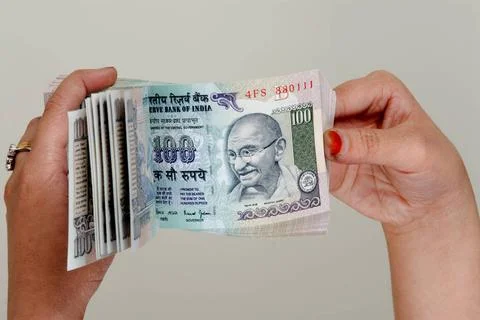 Indian currency, bundle of 100 rupees notes, counting with lady fingers, B... Foto stock